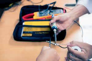 Engineer soldering audio cable